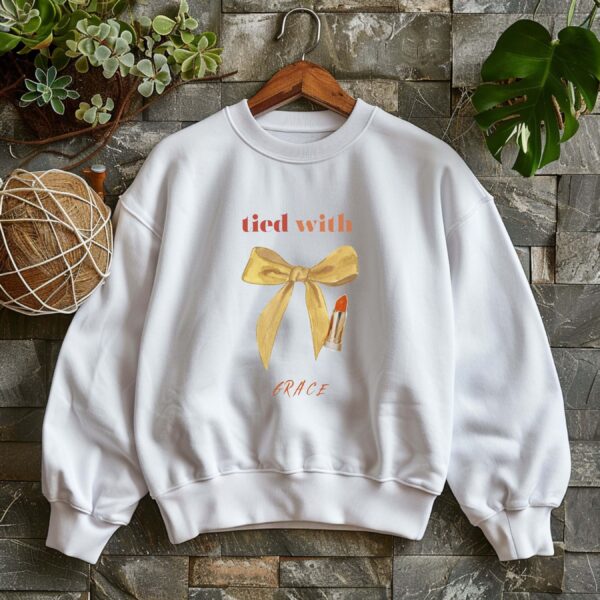 White sweatshirt with cute mustard bow and Tie with Grace text – feminine and minimal, from Bhoomkins’ Coquette collection